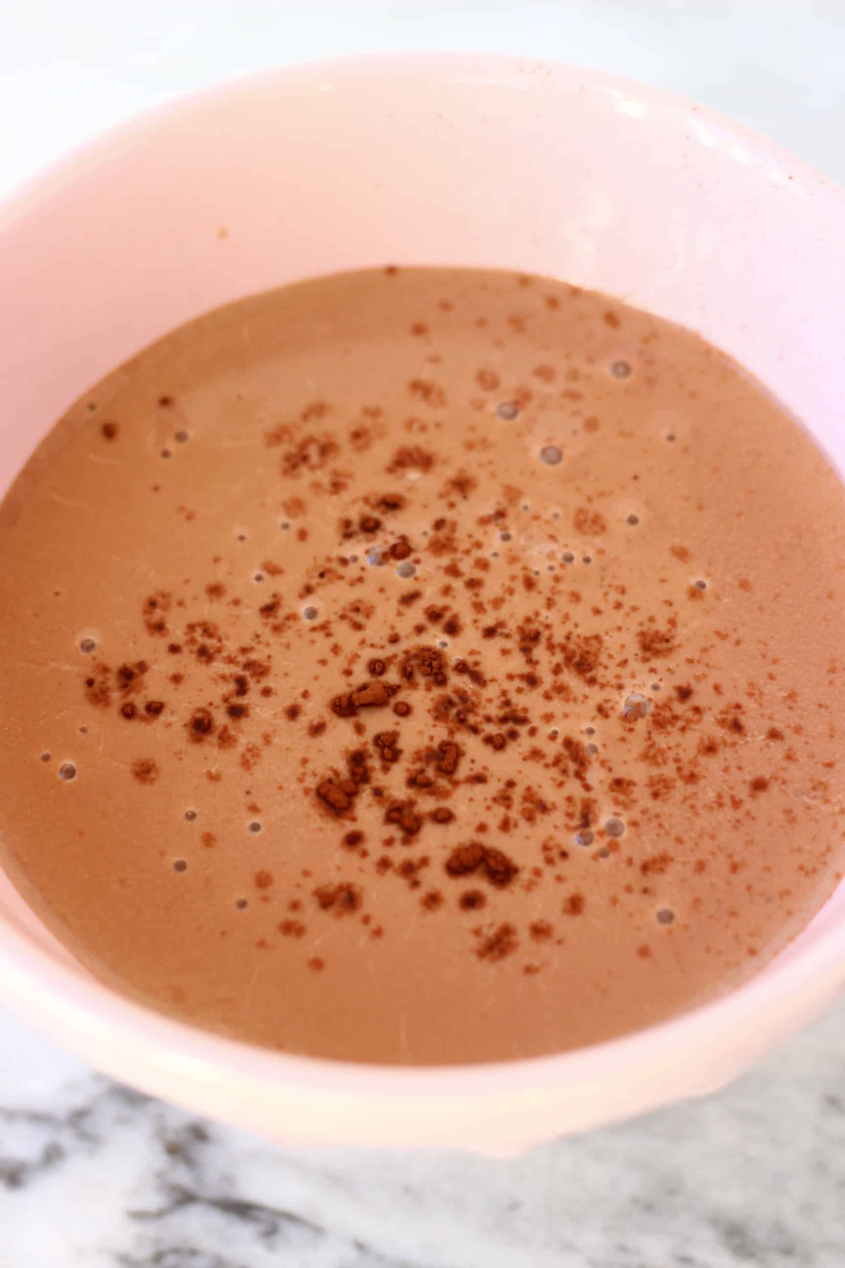 A bowl filled with vegan hot chocolate topped with cocoa powder