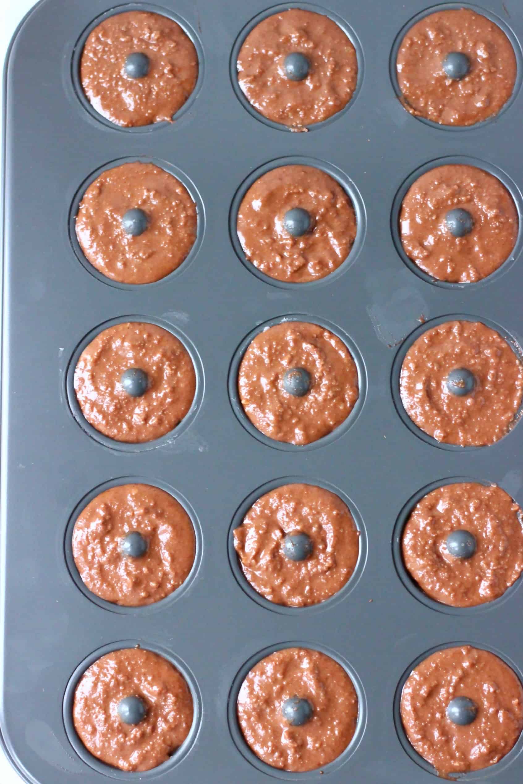 These Vegan Chocolate Baked Donuts are moist and fluffy and covered in a shiny chocolate glaze. A perfect snack or dessert for parties! Egg-free, dairy-free, gluten-free and refined sugar free. #rhiansrecipes #donuts #vegan #glutenfree #dairyfree Raw chocolate donut batter in a mini donut tin