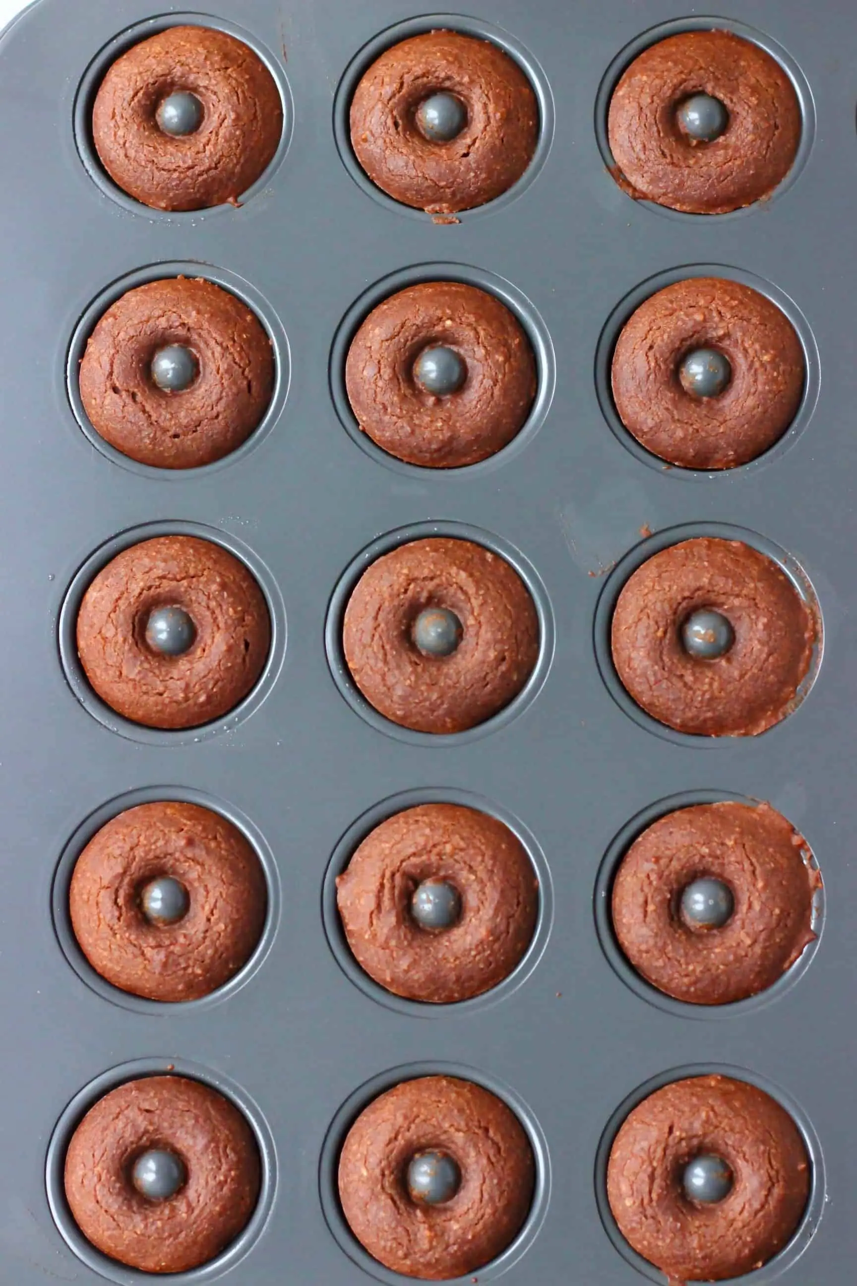 Cooked chocolate donuts in a mini donut tin