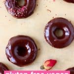 Chocolate glazed mini chocolate donuts on a sheet of brown baking paper decorated with dried roses