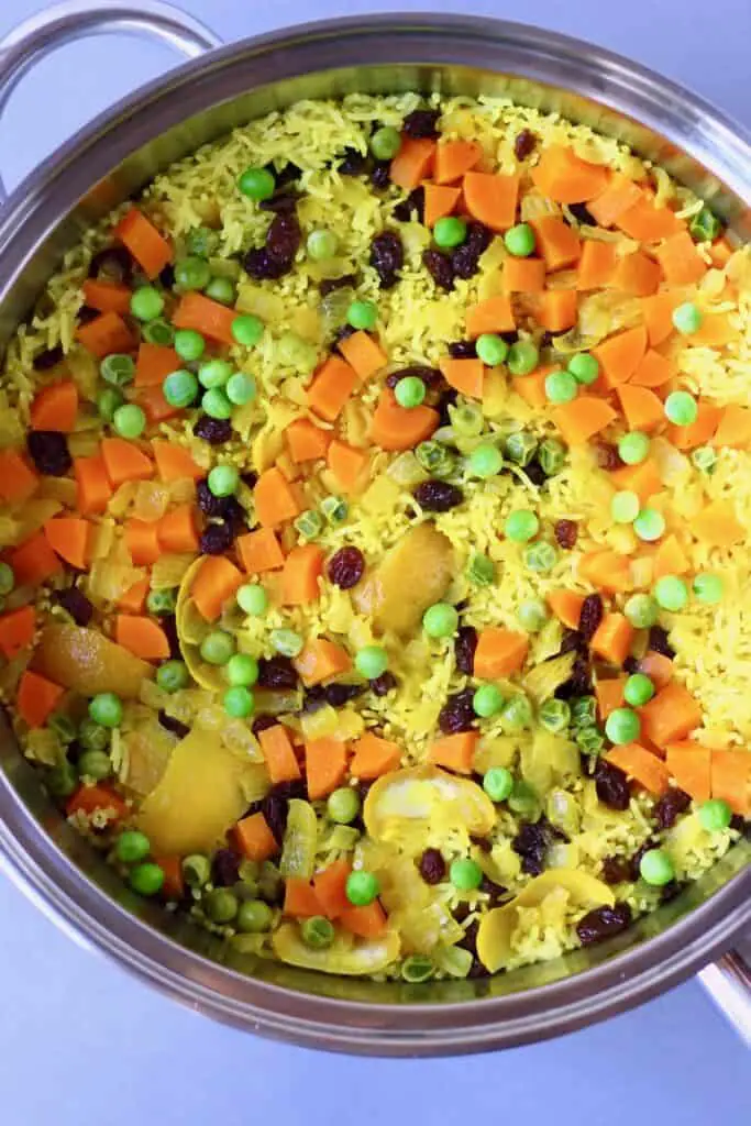 Photo of yellow rice with vegetables in a large saucepan taken from above