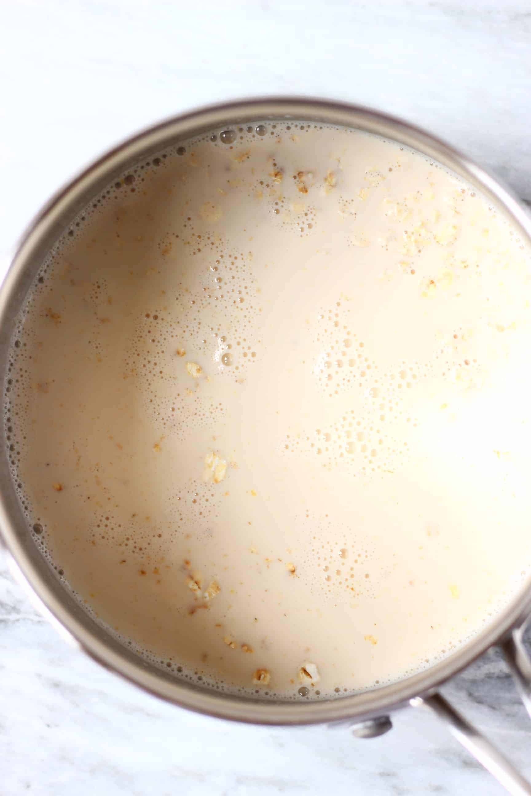 Oats, mashed banana and plant-based milk in a pan