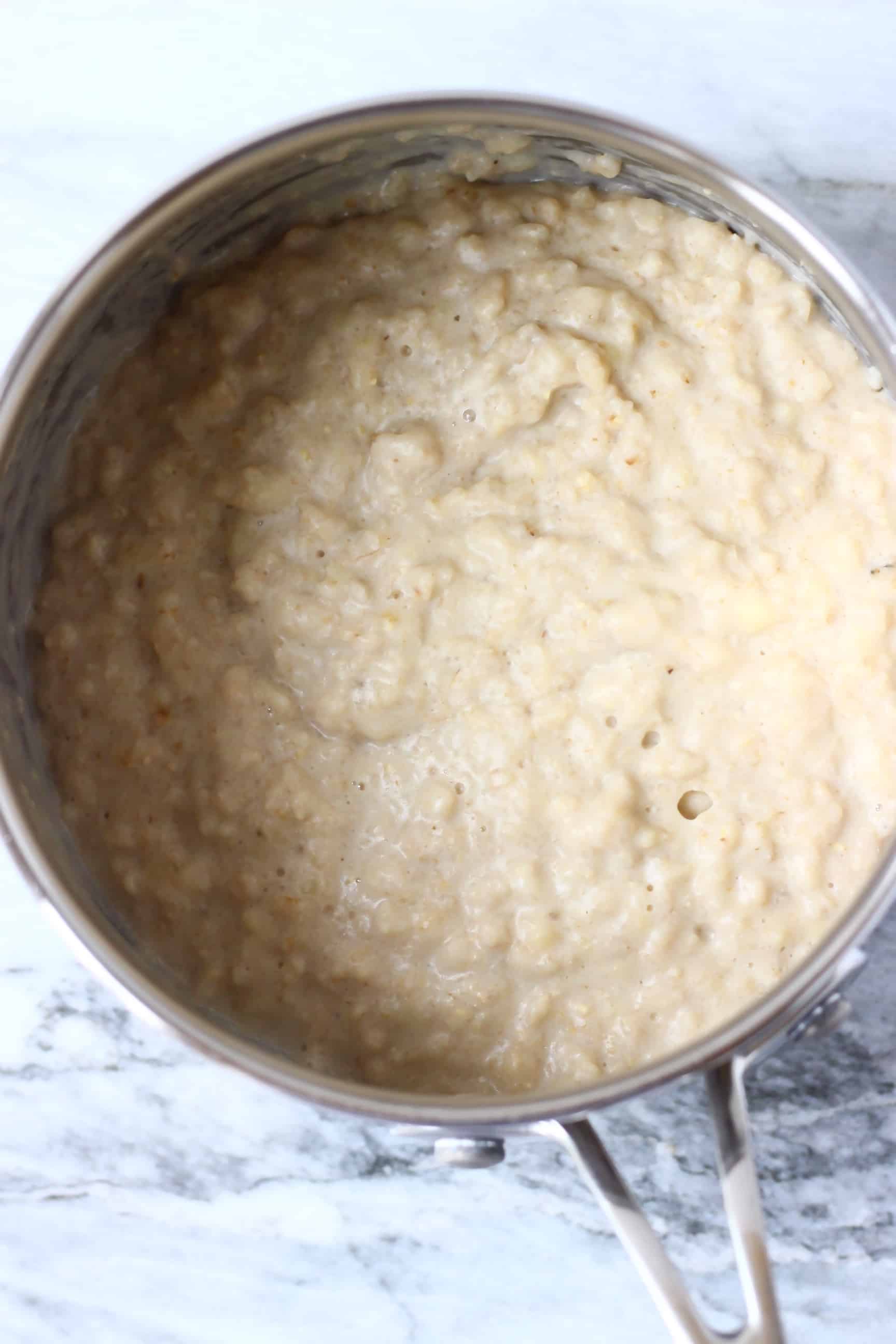 This Vegan Banana Oatmeal is comforting and warming, sweet and creamy and free from added sugar! It makes the perfect filling and nutritious breakfast. Egg-free, dairy-free, refined sugar free, no added sugar and gluten-free. #rhiansrecipes #vegan #glutenfree #dairyfree #breakfast #banana Cooked vegan banana oatmeal in a pan