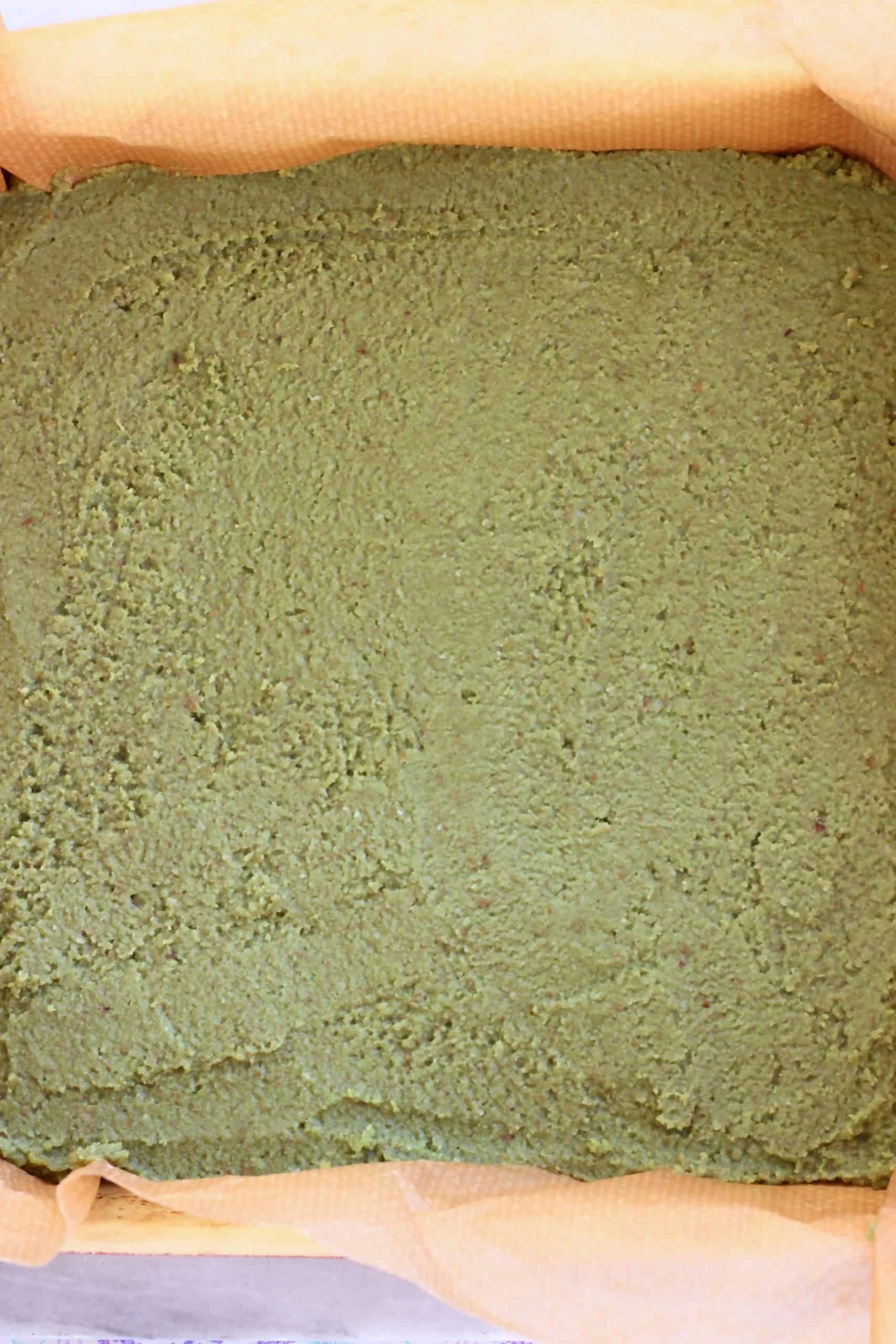 Gluten-free vegan matcha brownie batter in a square baking tin lined with baking paper