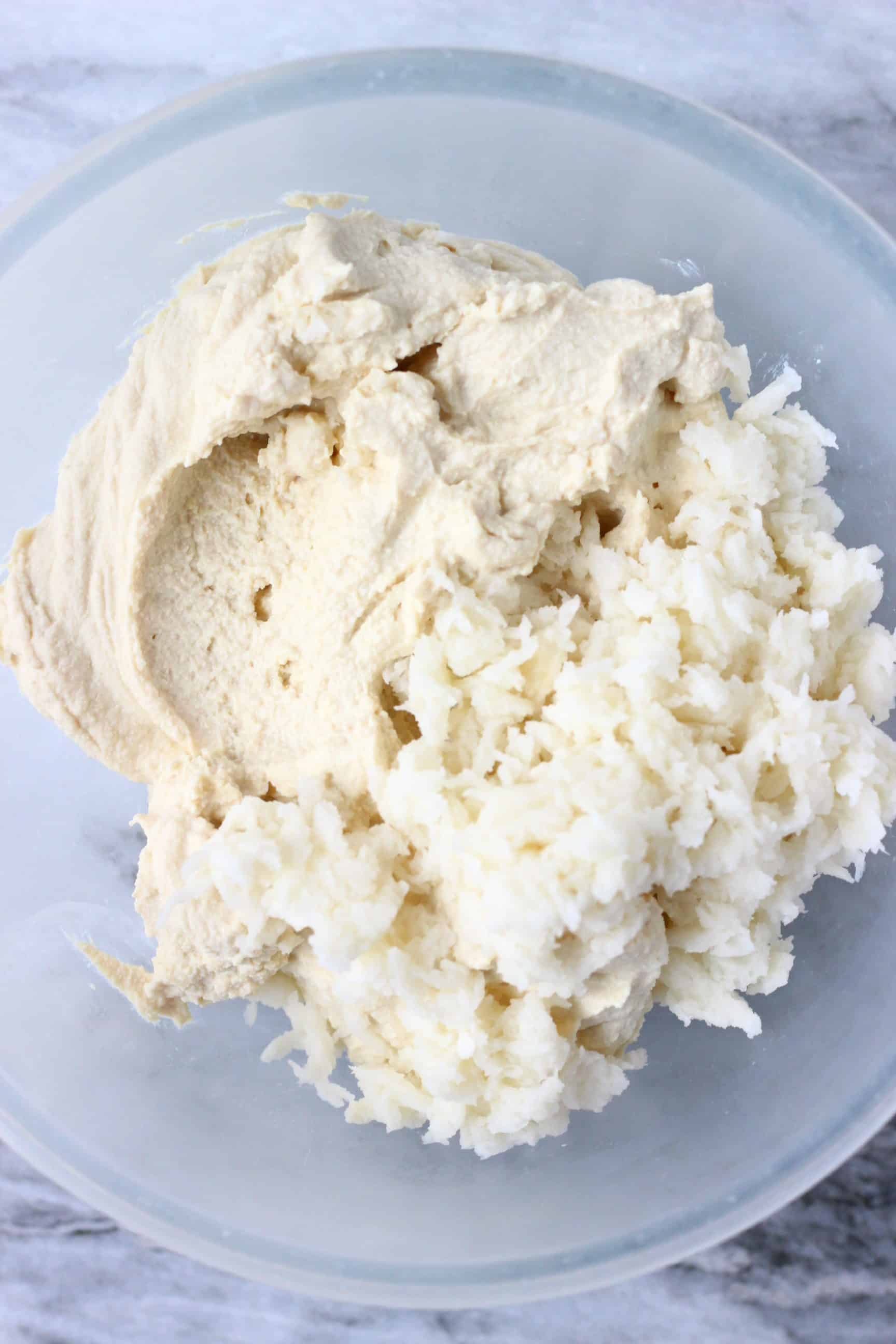 Blended tofu and breadcrumbs in a glass bowl against a marble background