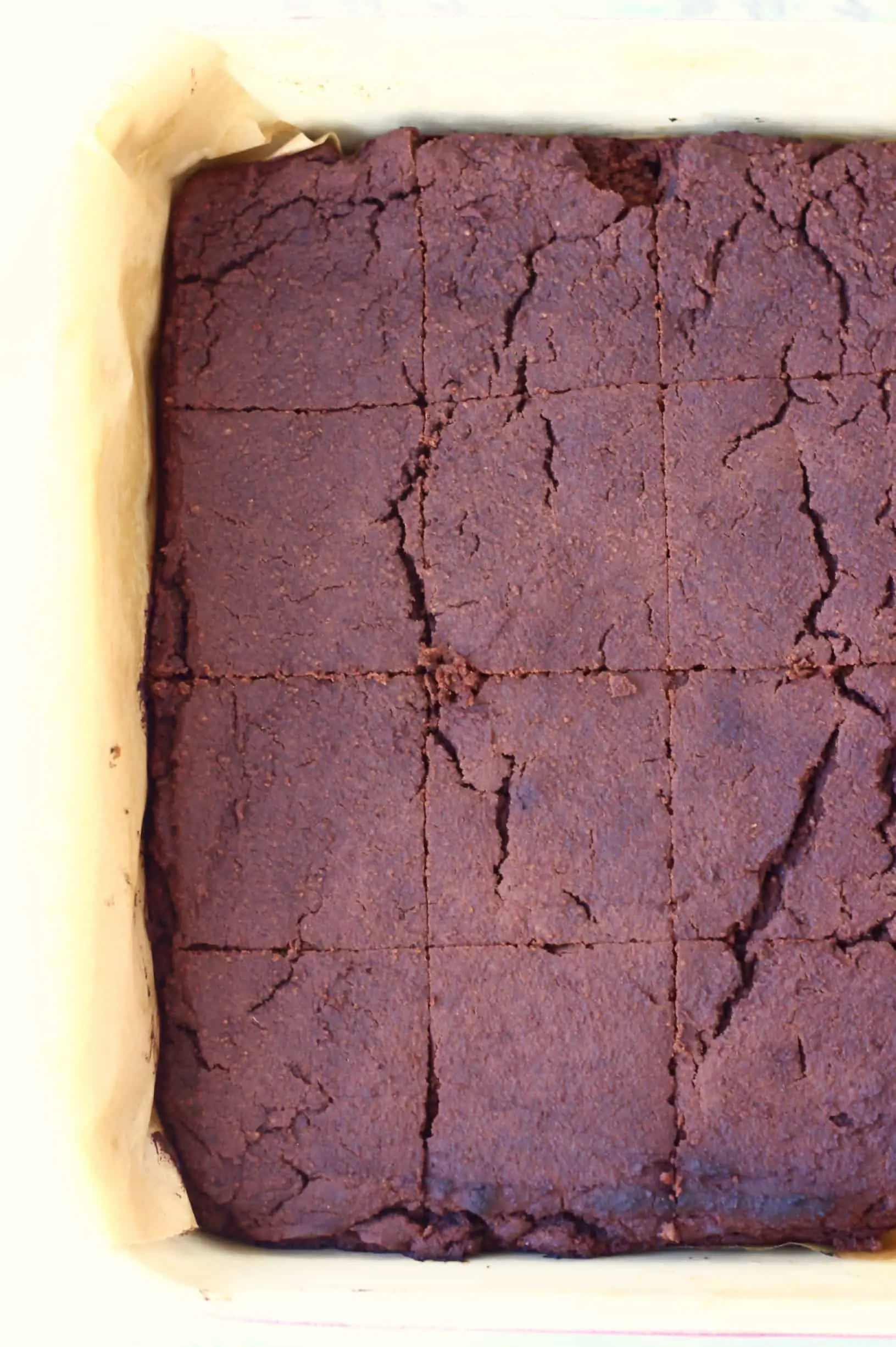 Vegan black bean brownies cut into squares in a square baking tin lined with baking paper