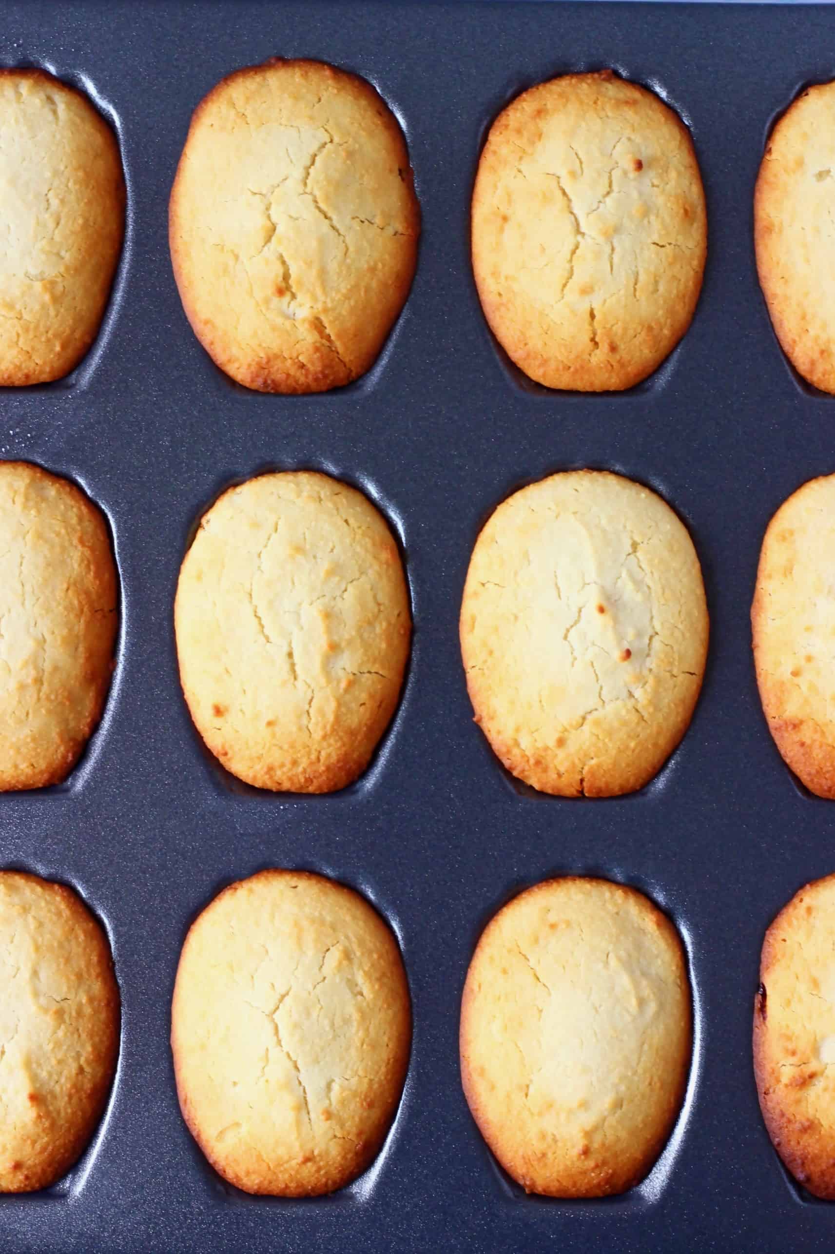 Twelve gluten-free vegan madeleines in a silver madeleine tin