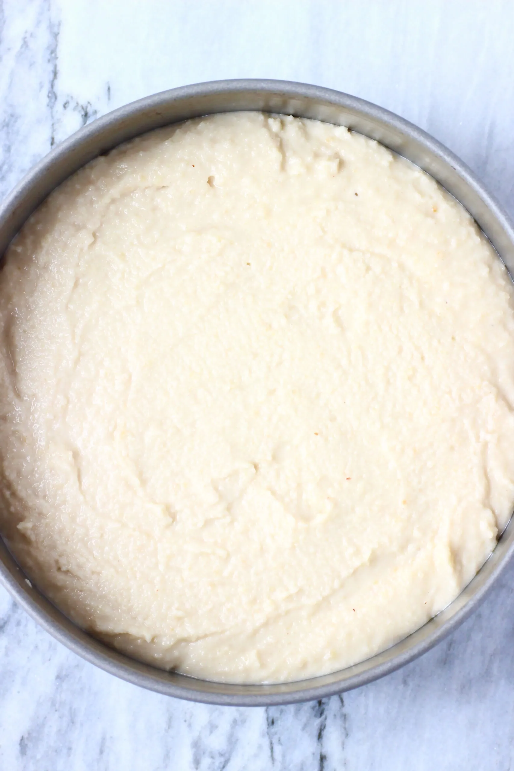 Raw gluten-free vegan lemon drizzle cake batter in a springform baking tin