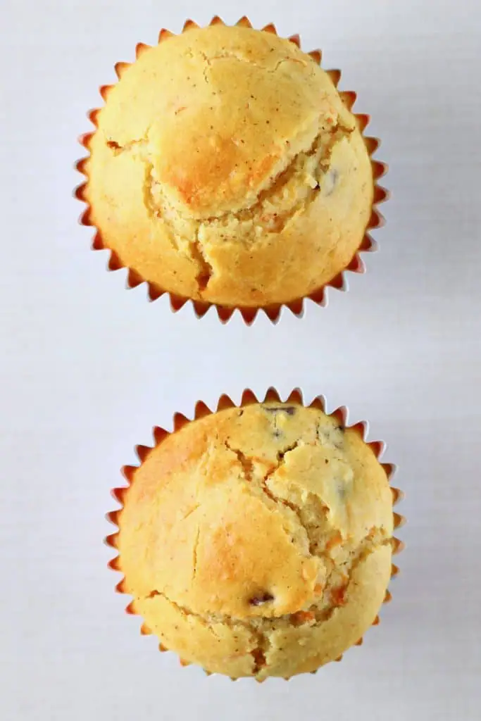 Two carrot cake cupcakes against a white background