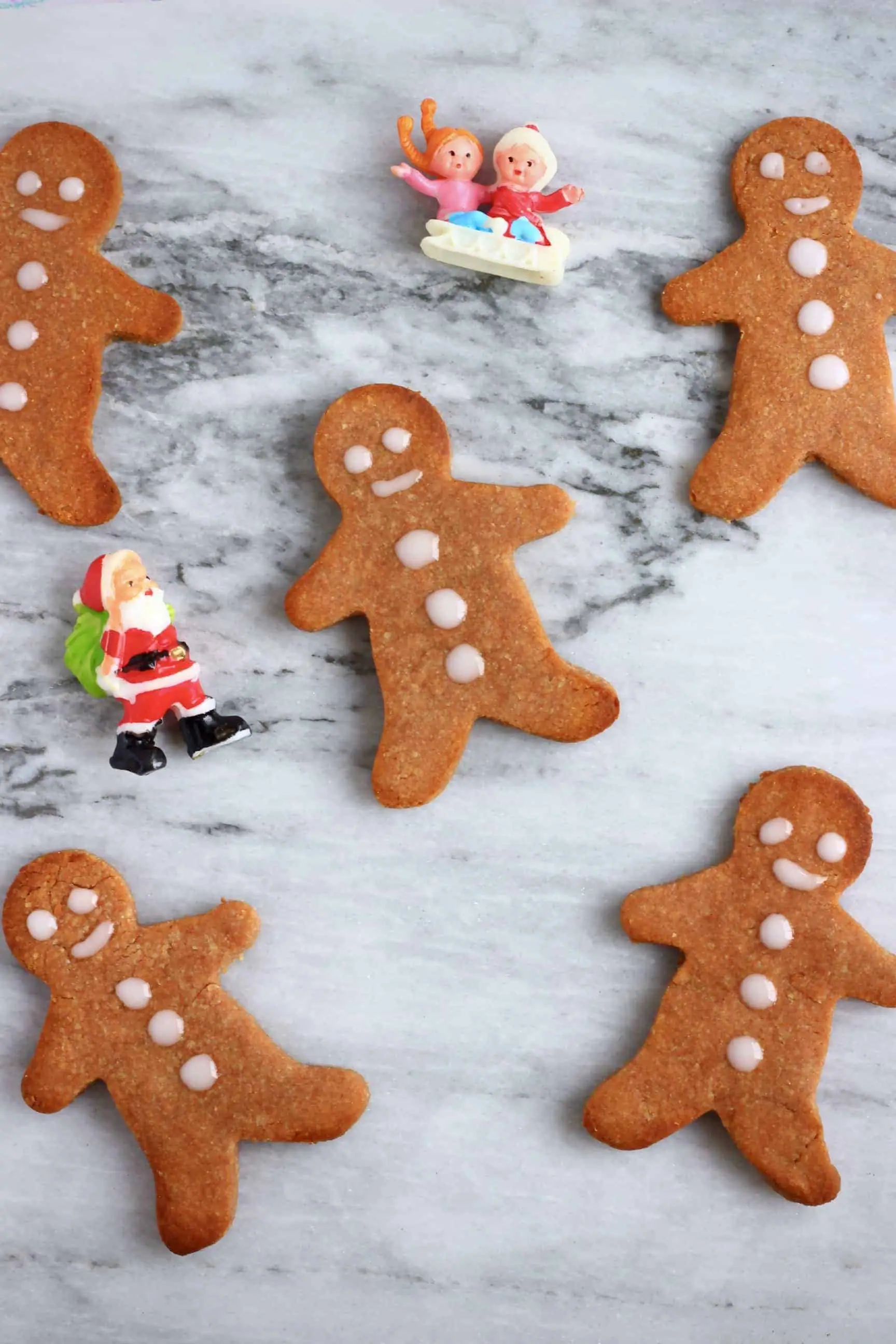 Five gluten-free vegan gingerbread cookies on a marble background