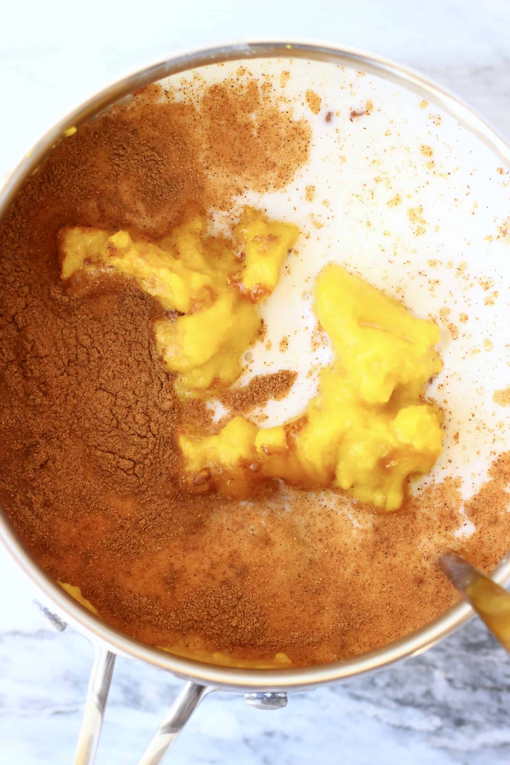 This Gluten-Free Vegan Pumpkin Pie is perfectly spiced, rich and creamy, and flaky, crispy and buttery. The perfect dessert for autumn/fall, Thanksgiving and Christmas. Egg-free, dairy-free and refined sugar free. #vegan #rhiansrecipes #dairyfree #glutenfree #pie #pumpkin #thanksgiving Pumpkin purée, spices and milk in a saucepan