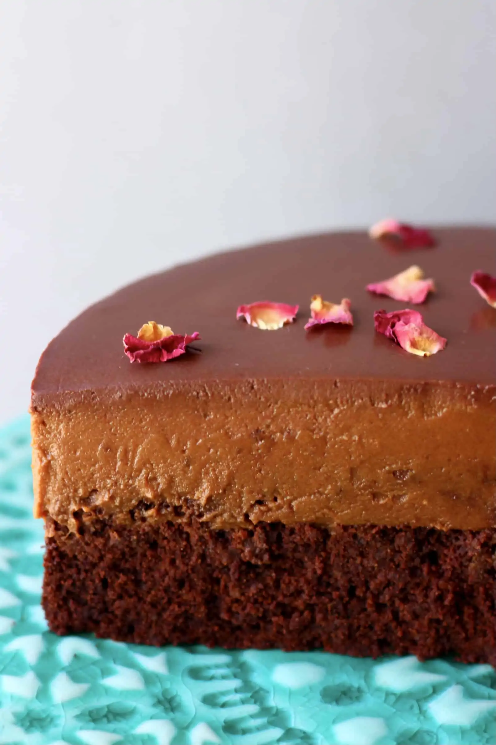 A sliced gluten-free vegan chocolate mousse cake with sponge, chocolate mousse and ganache
