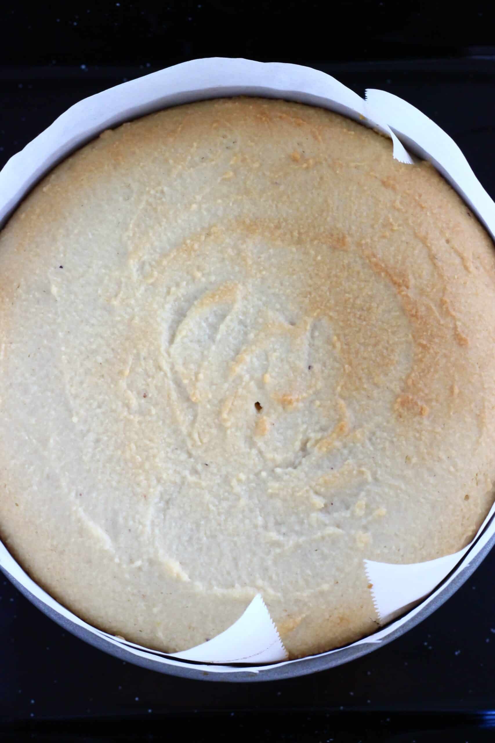 A baked gluten-free vegan pineapple upside down cake in a round springform baking tin lined with baking paper