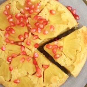 Gluten-free vegan pineapple upside down cake on a plate with a slice cut out of it