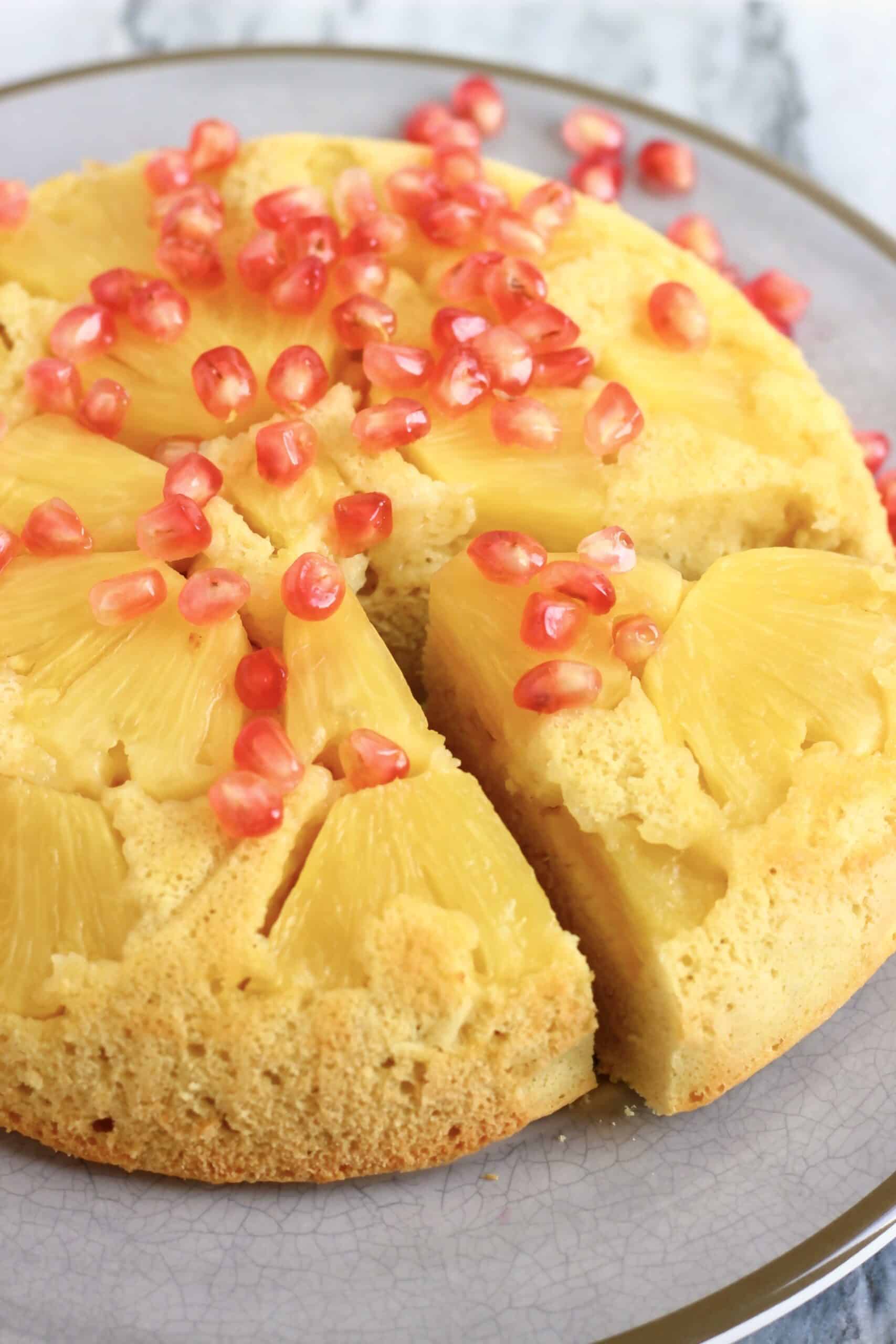 Gluten-free vegan pineapple upside down cake on a plate with a slice cut out of it