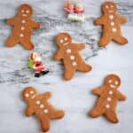 Five gluten-free vegan gingerbread cookies on a marble background