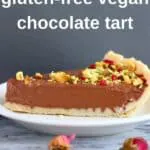Photo of a slice of chocolate tart on a white plate with a grey background