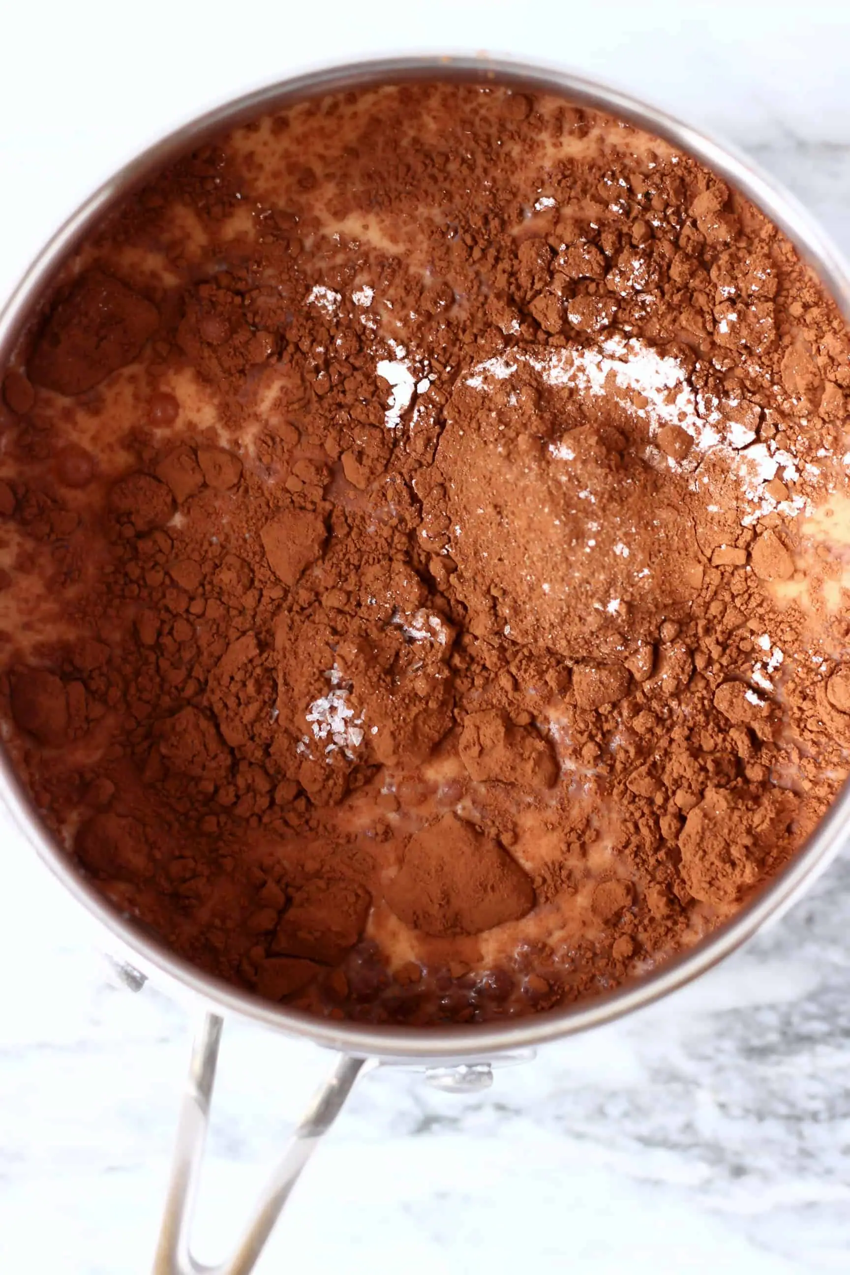 A silver pan with plant-based milk and cocoa powder 