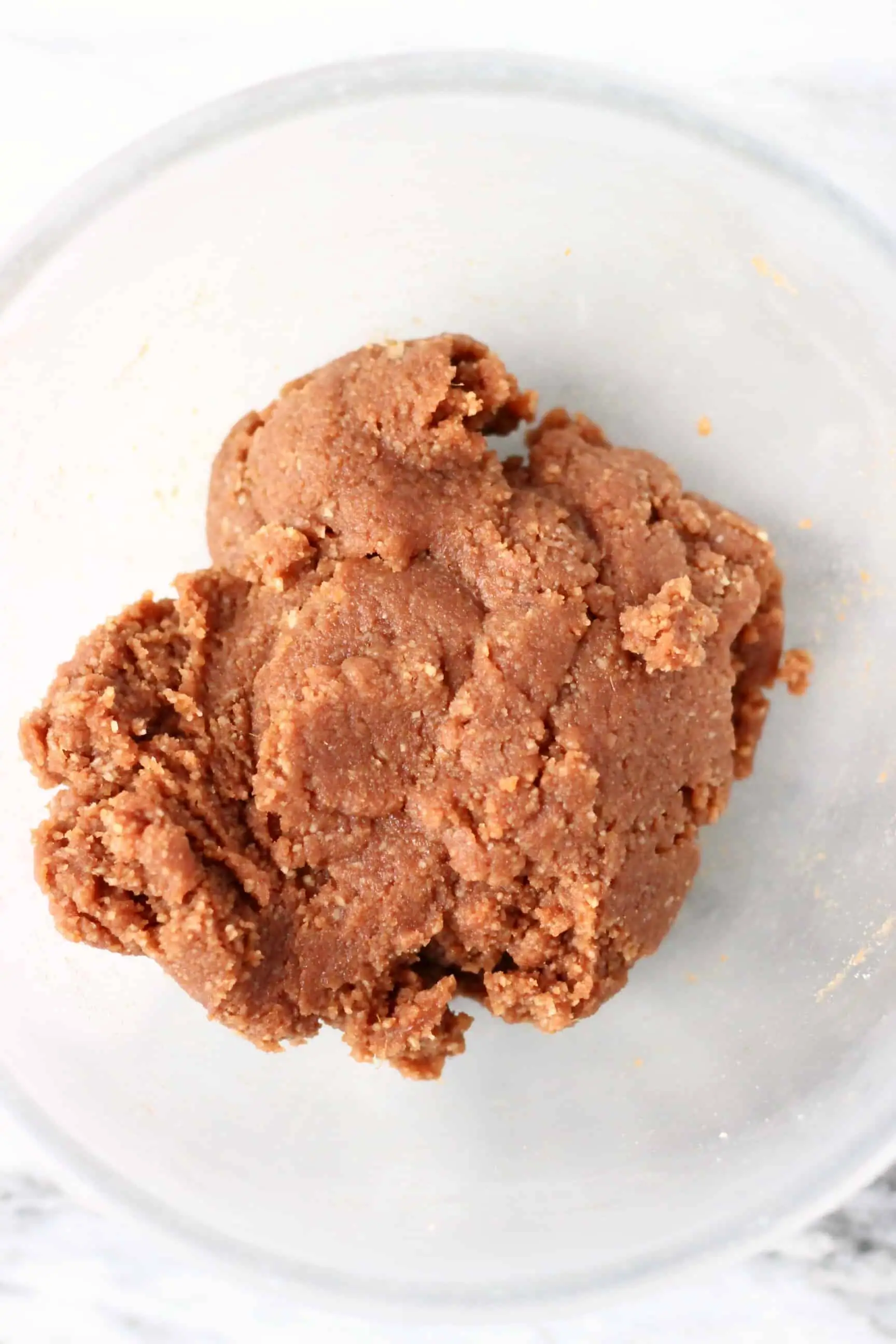 Raw gluten-free vegan gingerbread cookie dough in a glass mixing bowl 