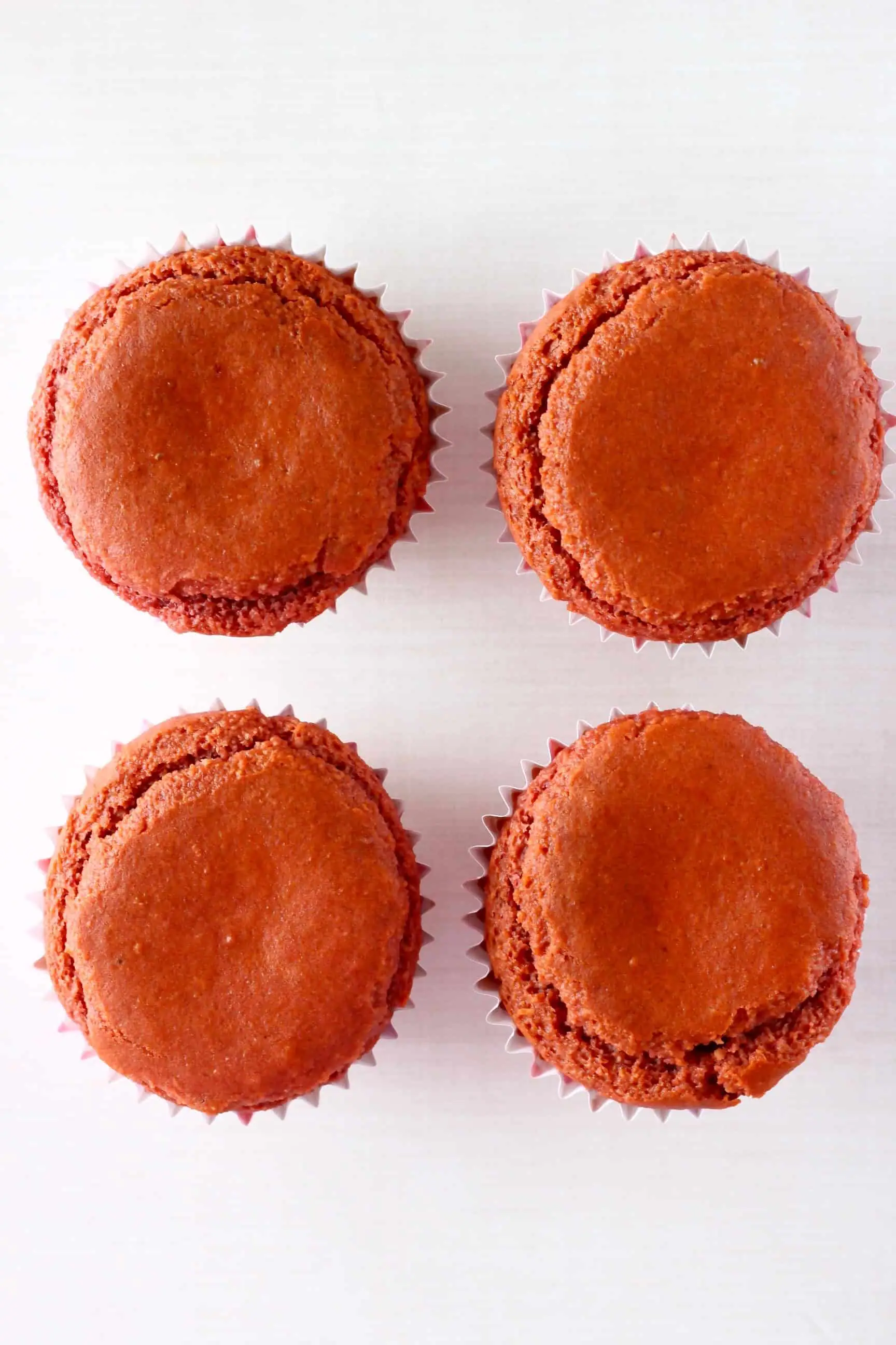 Four gluten-free vegan red velvet cupcakes in cupcake cases