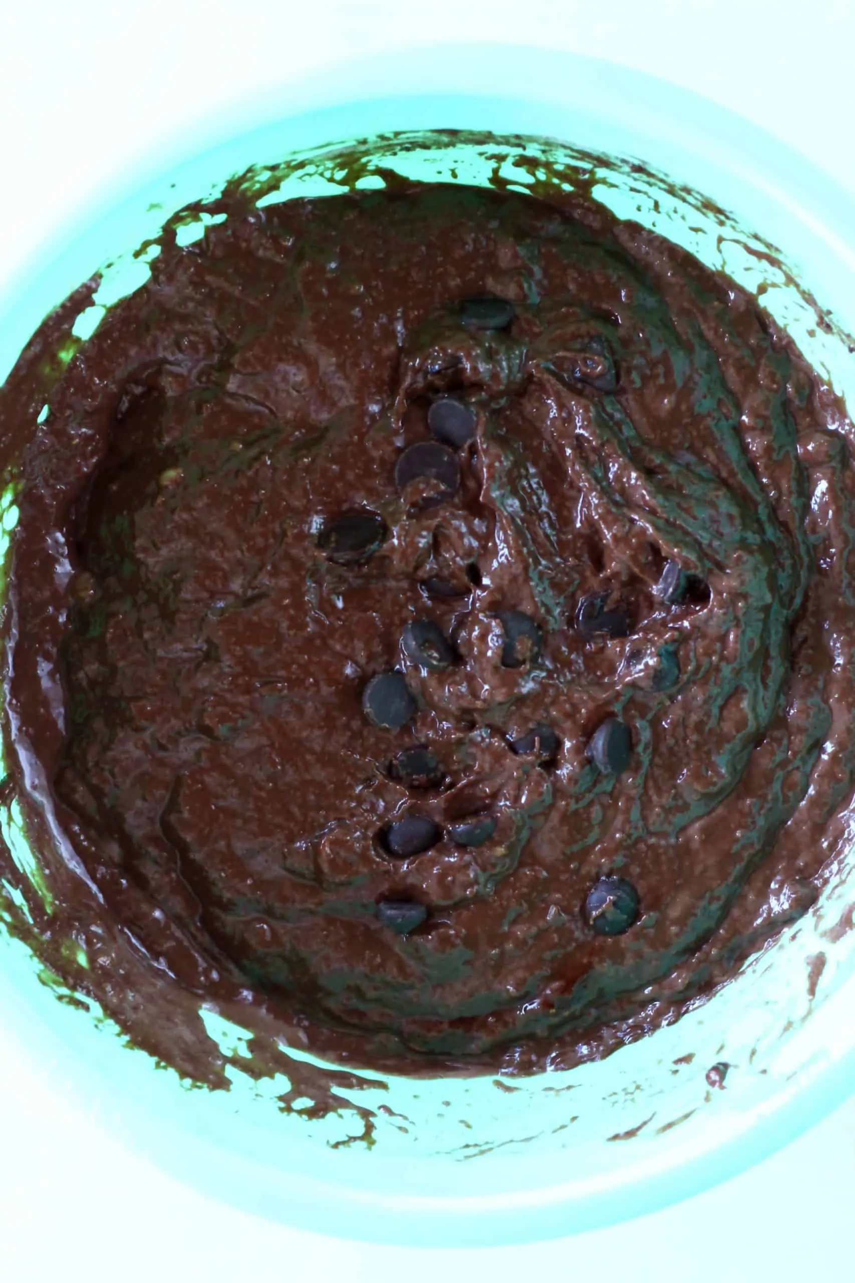 Raw gluten-free vegan chocolate muffin batter with chocolate chips in a mixing bowl