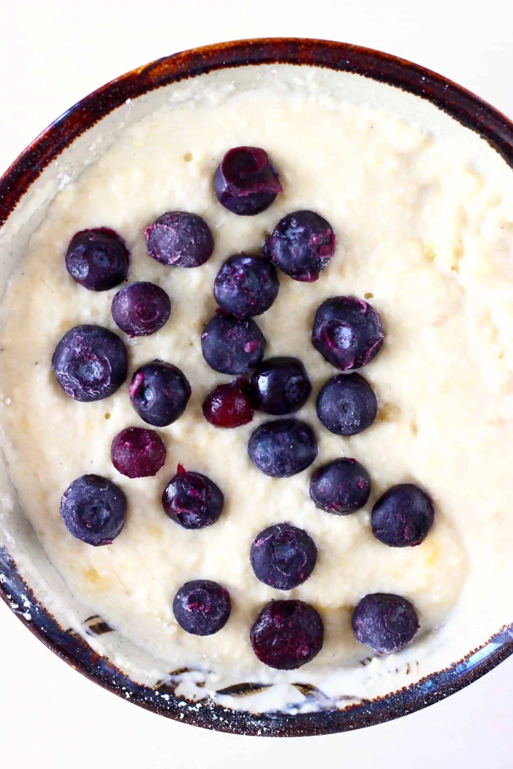 Raw gluten-free vegan blueberry banana muffin batter with blueberries in a bowl