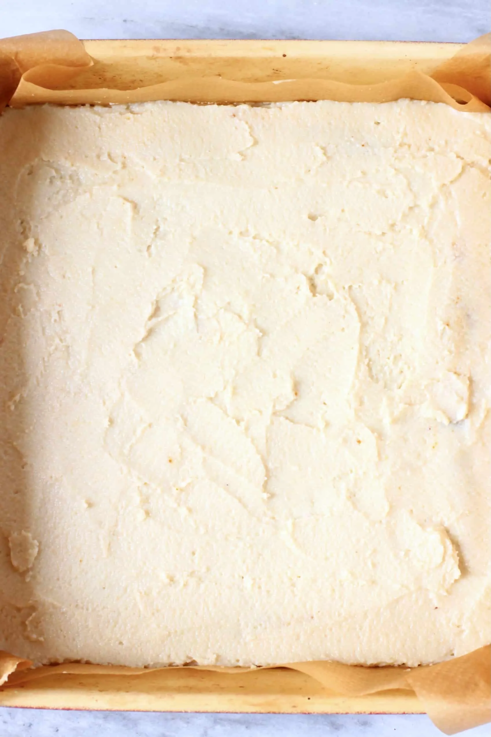 Raw gluten-free vegan tiramisu sponge batter in a square baking tin lined with baking paper