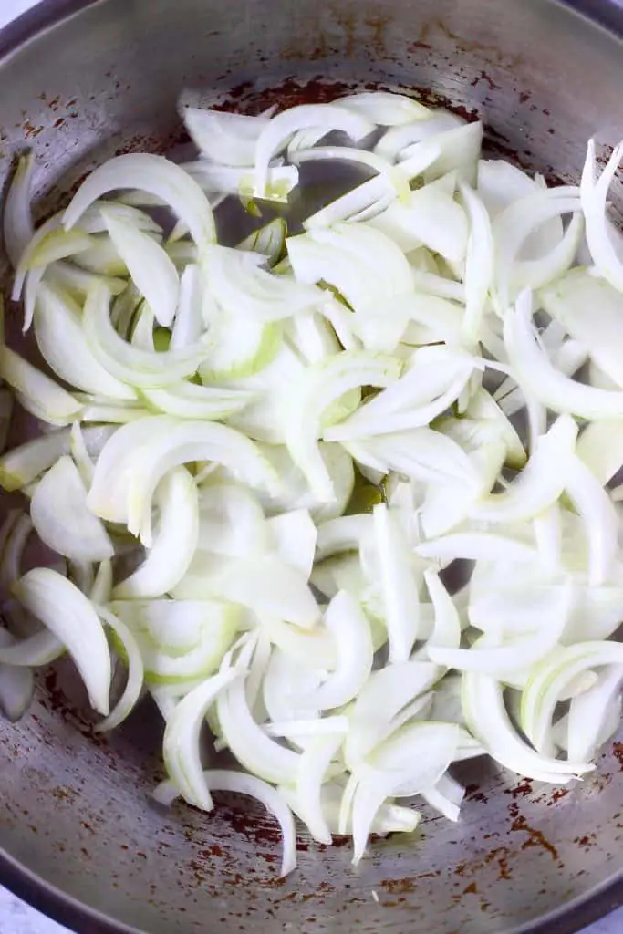 Sliced onions in a silver frying pan