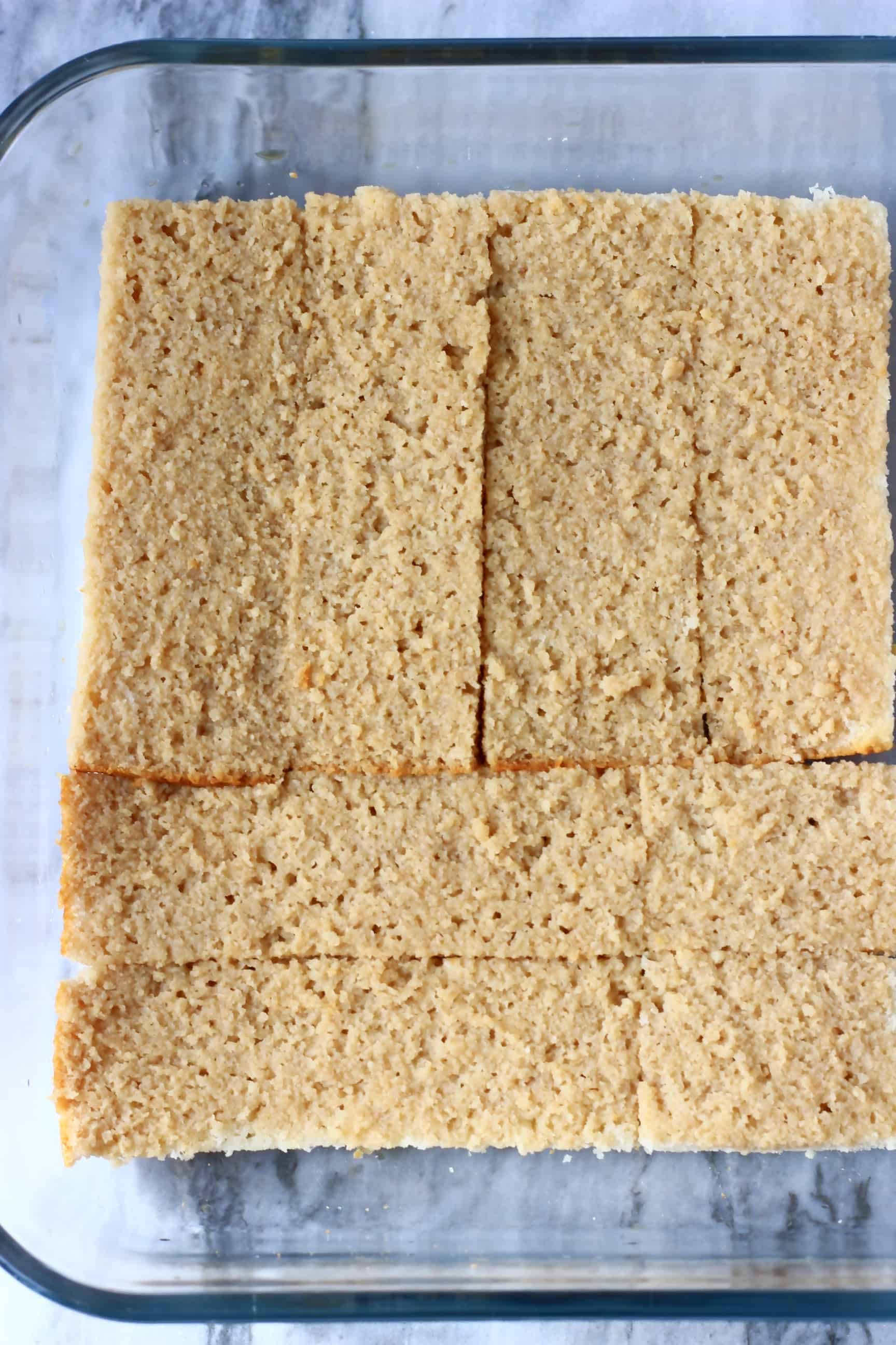 Photo of a large glass tray filled with rectangular sponges soaked in coffee