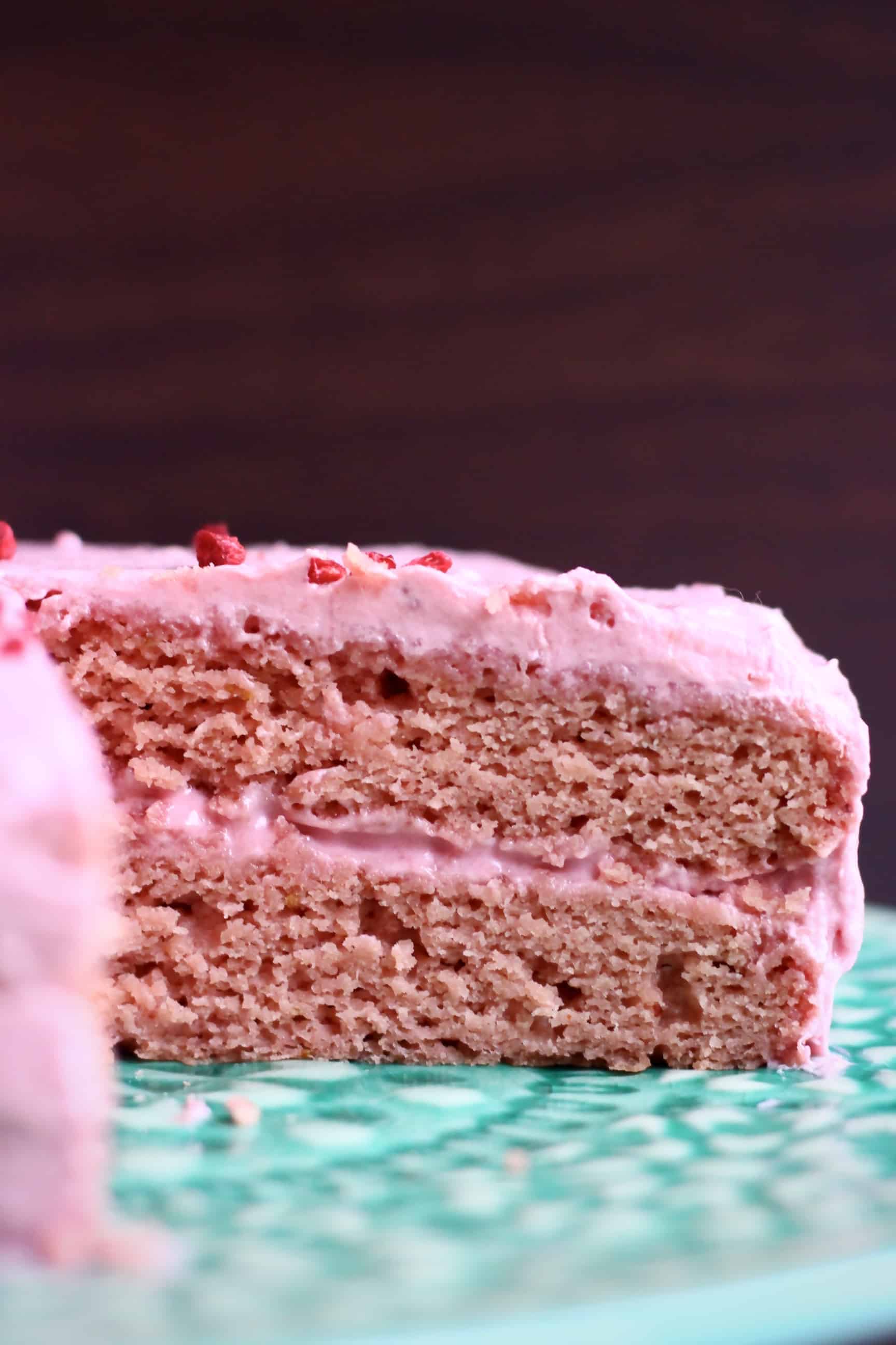 A gluten-free vegan strawberry cake with pink strawberry frosting