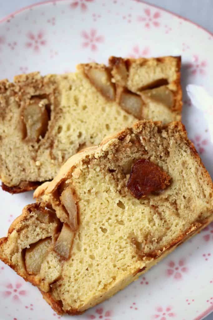 Photo of two slices of a loaf of apple bread on a white plate with pink flowers