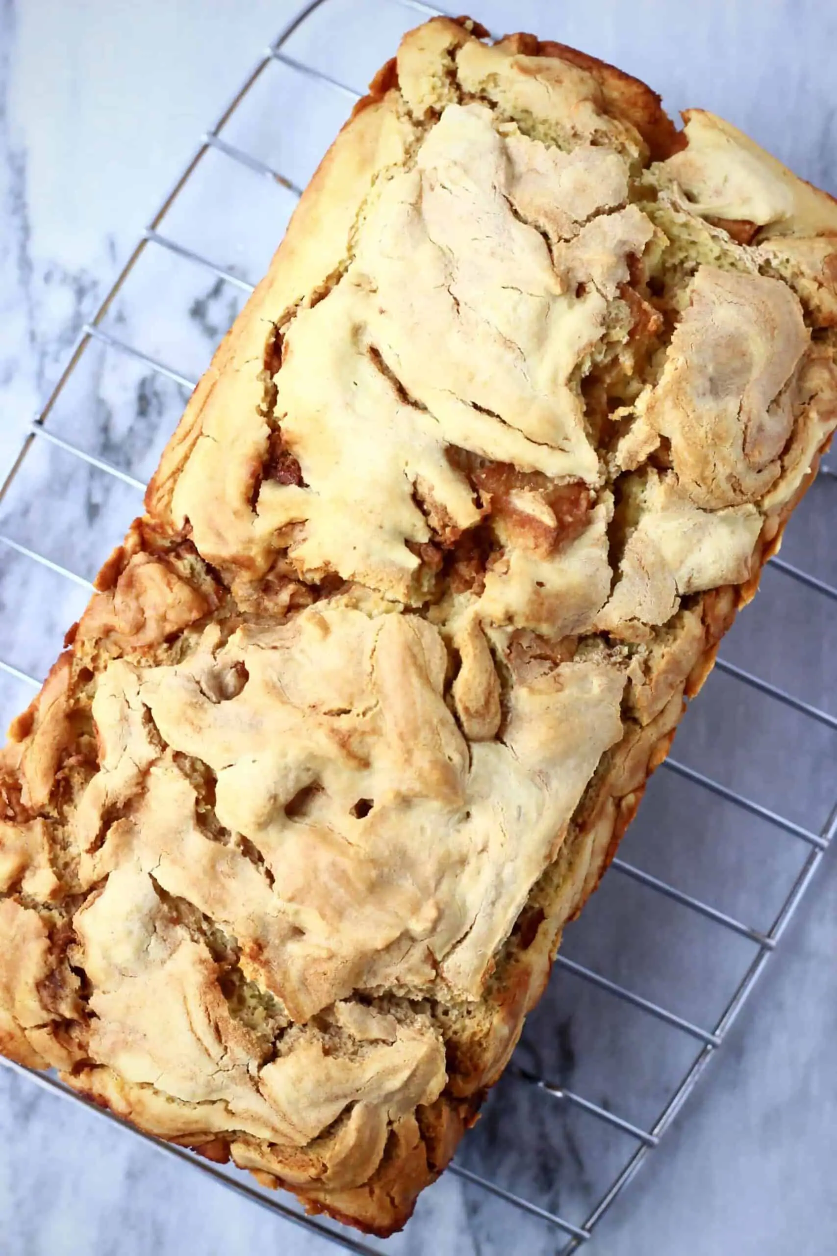A loaf of vegan apple bread on a wire rack