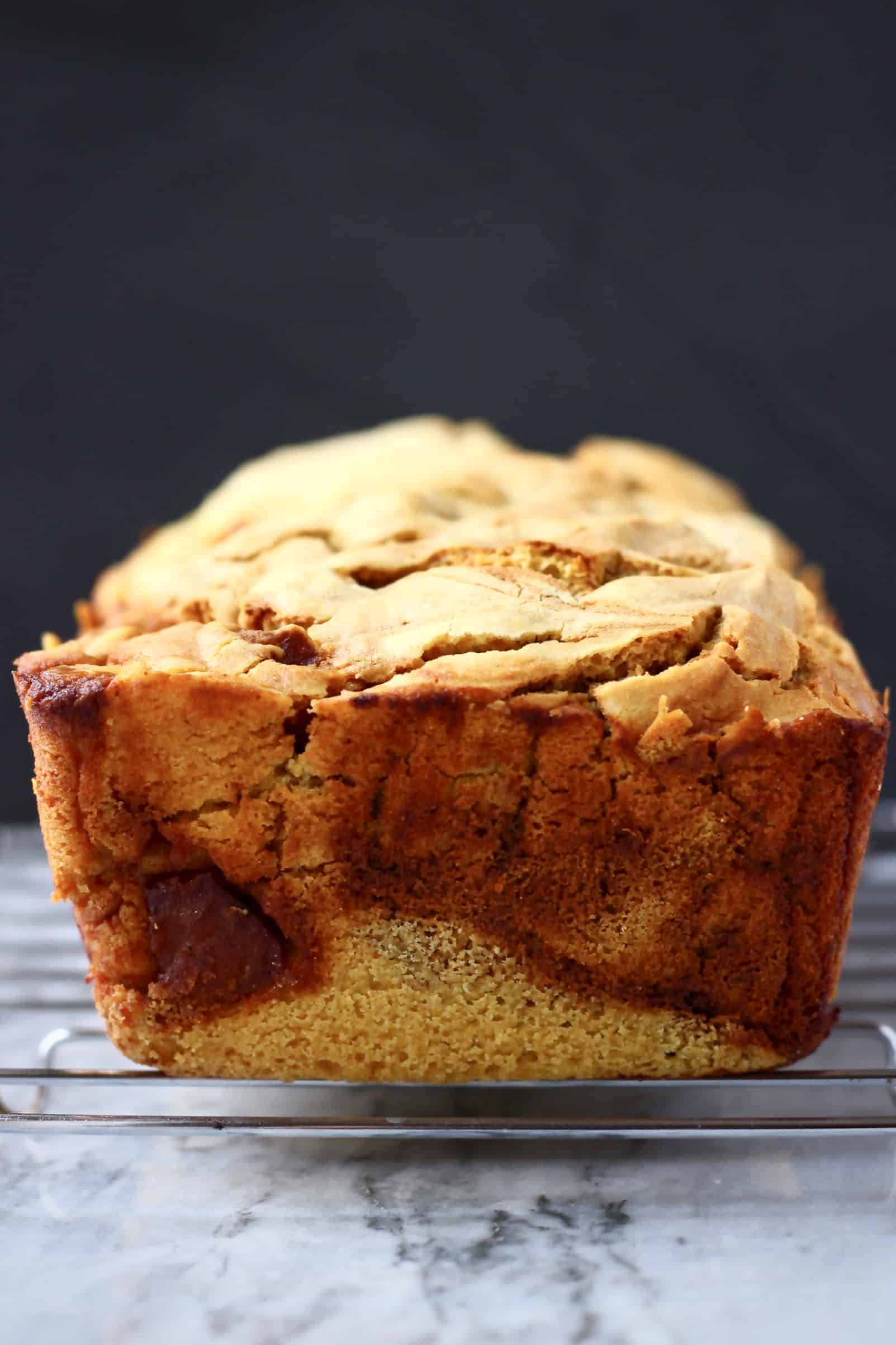 A loaf of vegan apple bread on a wire rack