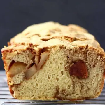 A sliced loaf of vegan apple bread on a wire rack