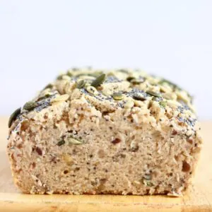 A sliced loaf of Gluten-Free Vegan Seeded Buckwheat Bread on a chopping board