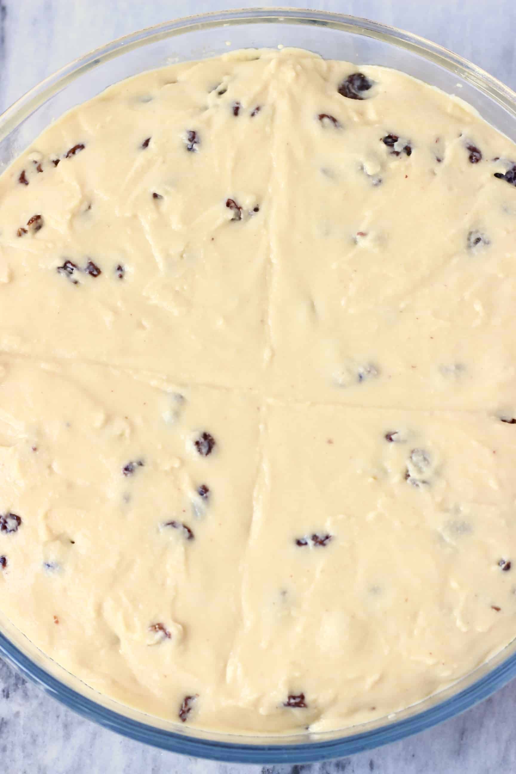 Gluten-Free Vegan Irish Soda Bread Gluten-Free Vegan Irish Soda Bread batter with raisins in a round glass baking dish with a cross marked on top