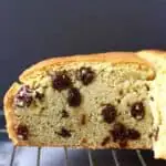 A sliced loaf of gluten-free vegan Irish soda bread with raisins on a wire rack