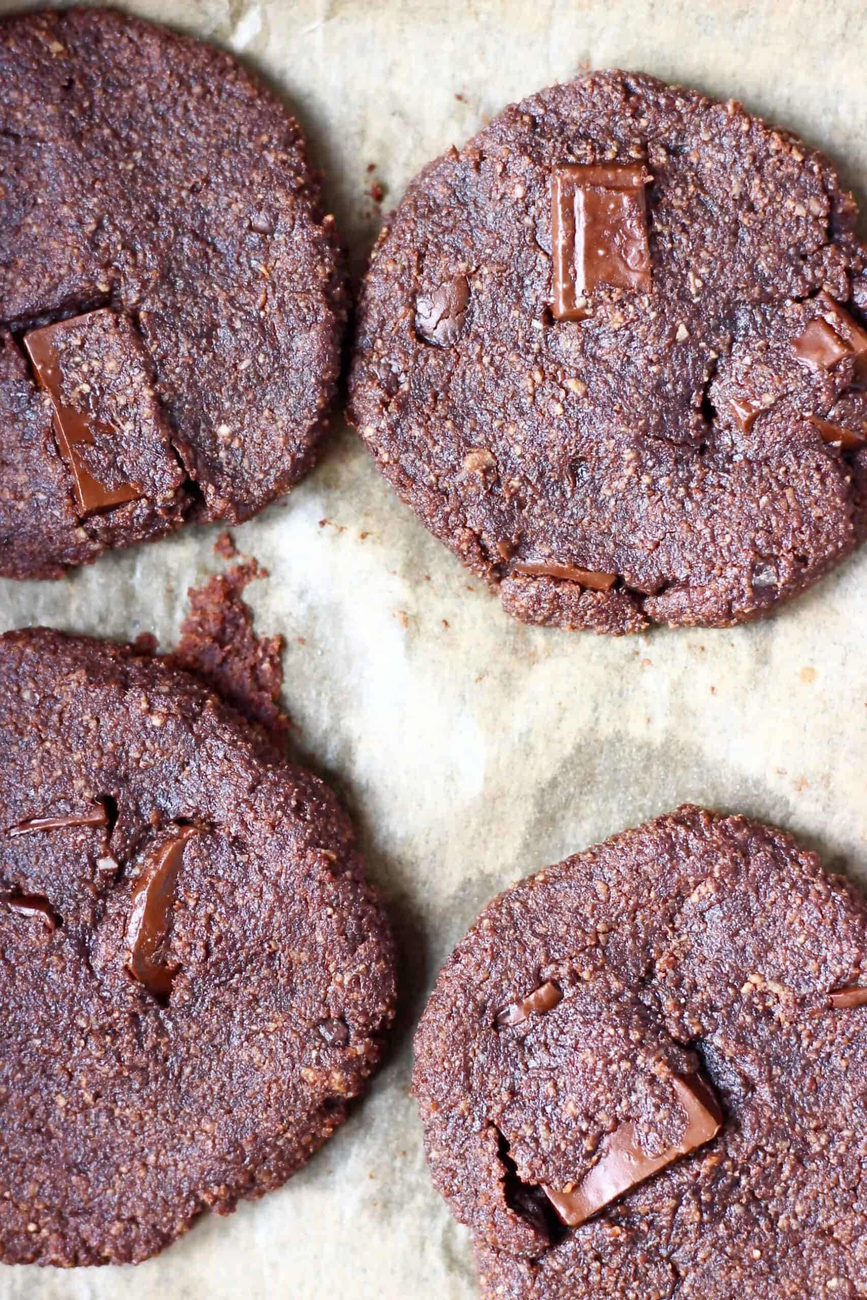 Four chocolate cookies on a sheet of brown baking paper