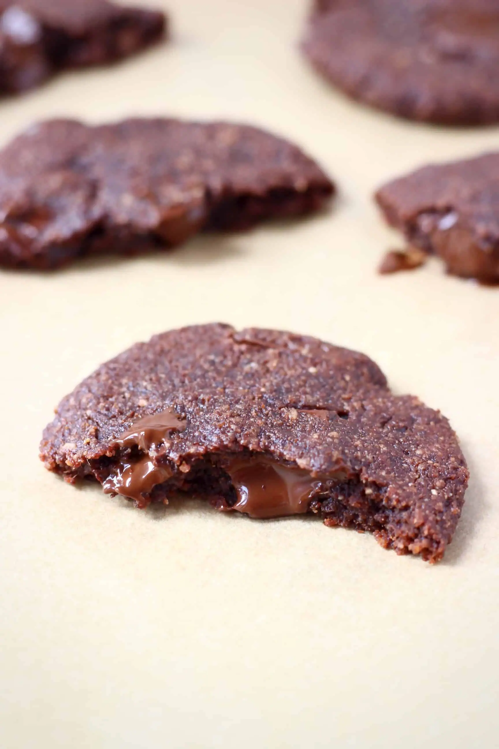A halved chocolate cookie on a sheet of brown baking paper