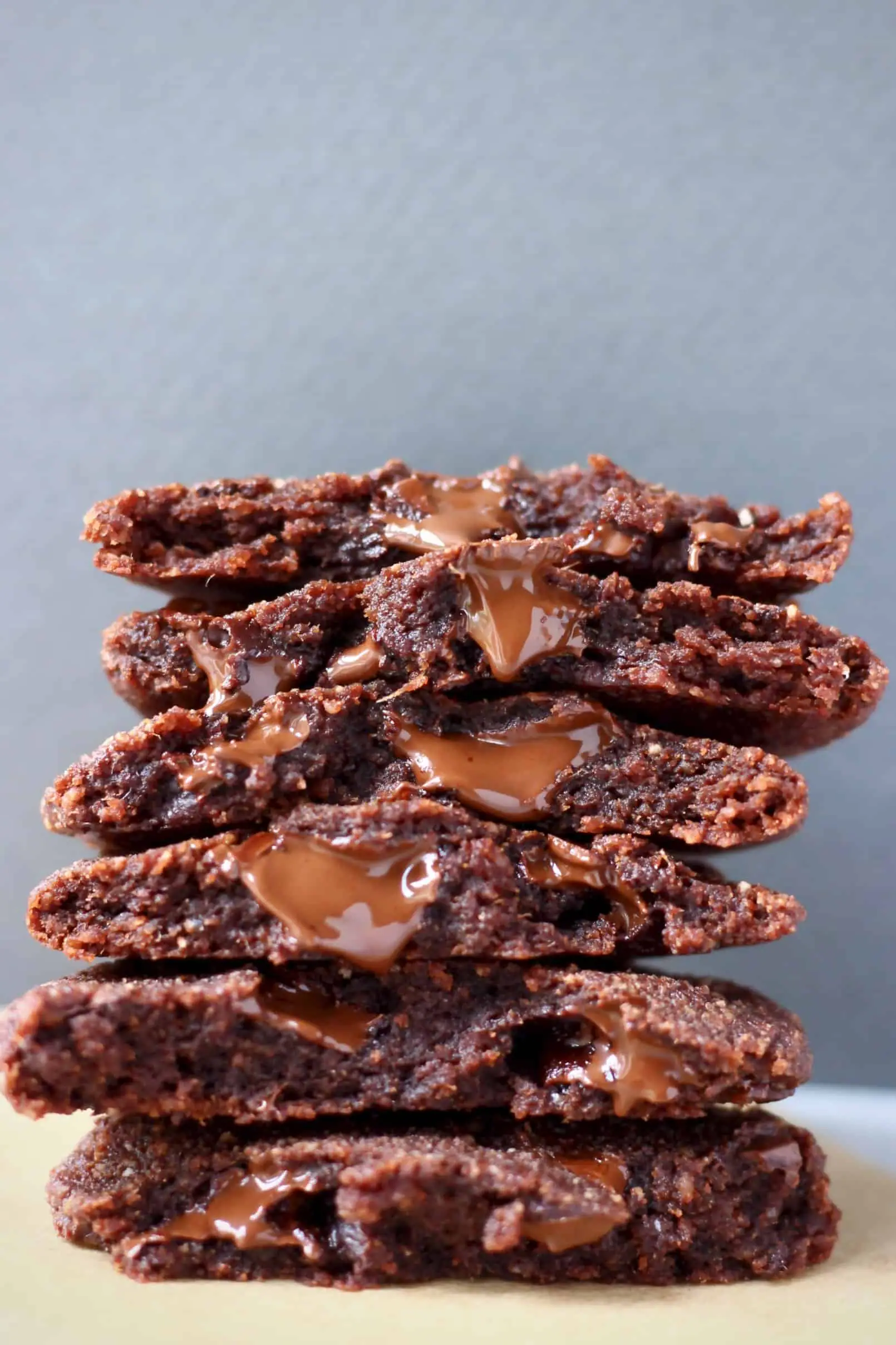 A stack of halved chocolate cookies against a grey background