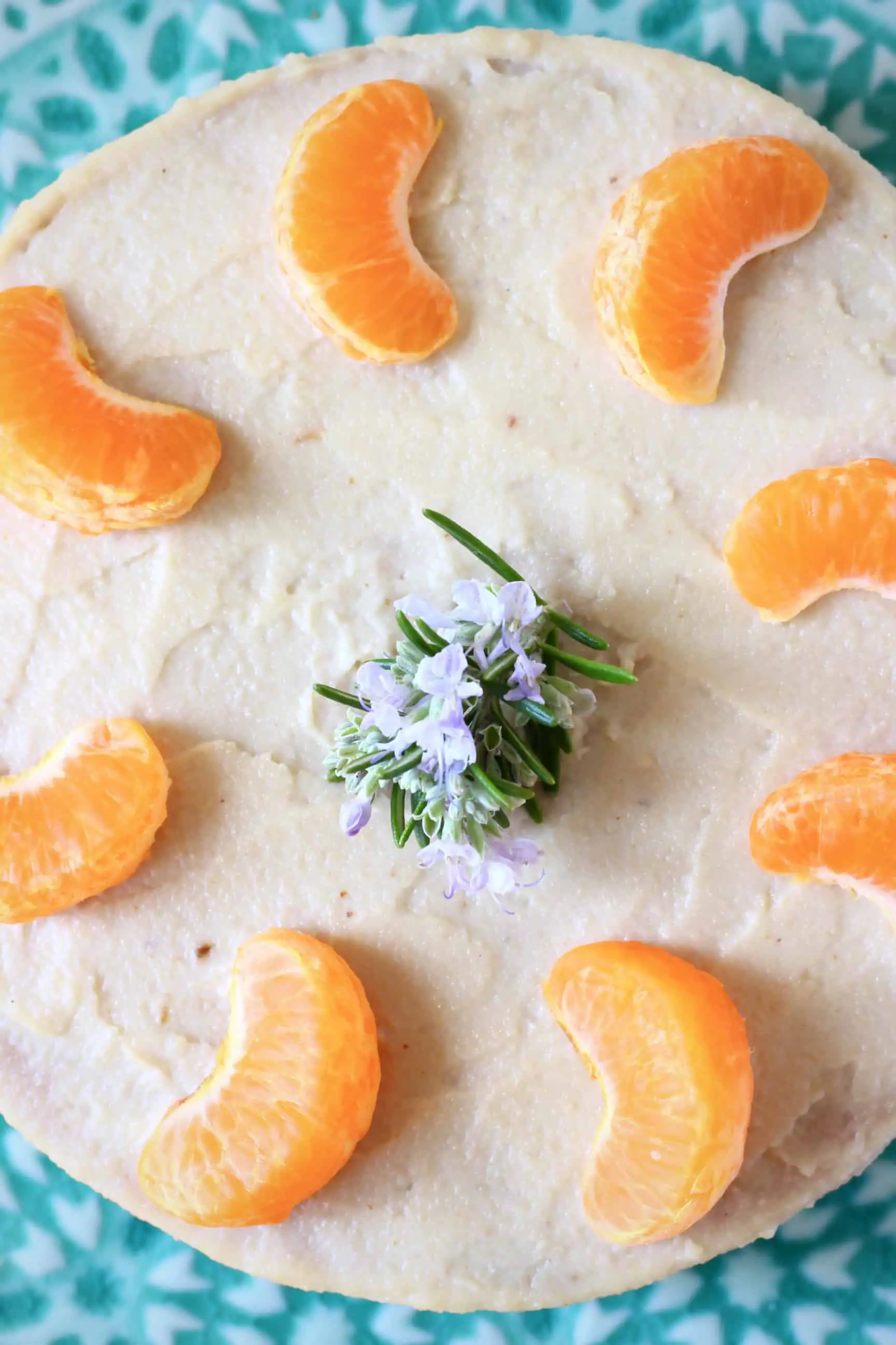 Gluten-free vegan orange cake topped with orange buttercream and clementine segments