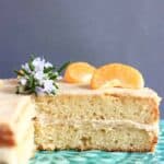 Sliced gluten-free vegan orange cake with buttercream topped with clementine segments