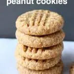 A stack of five peanut butter cookies on a marble slab against a grey background