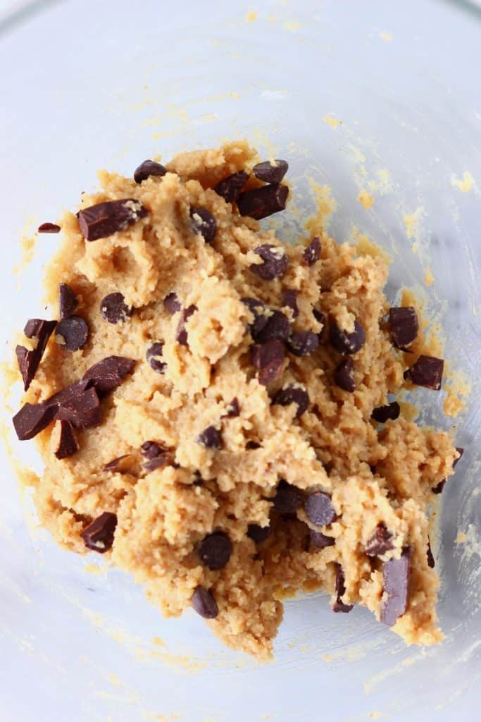 Raw chocolate chip cookie dough in a glass mixing bowl