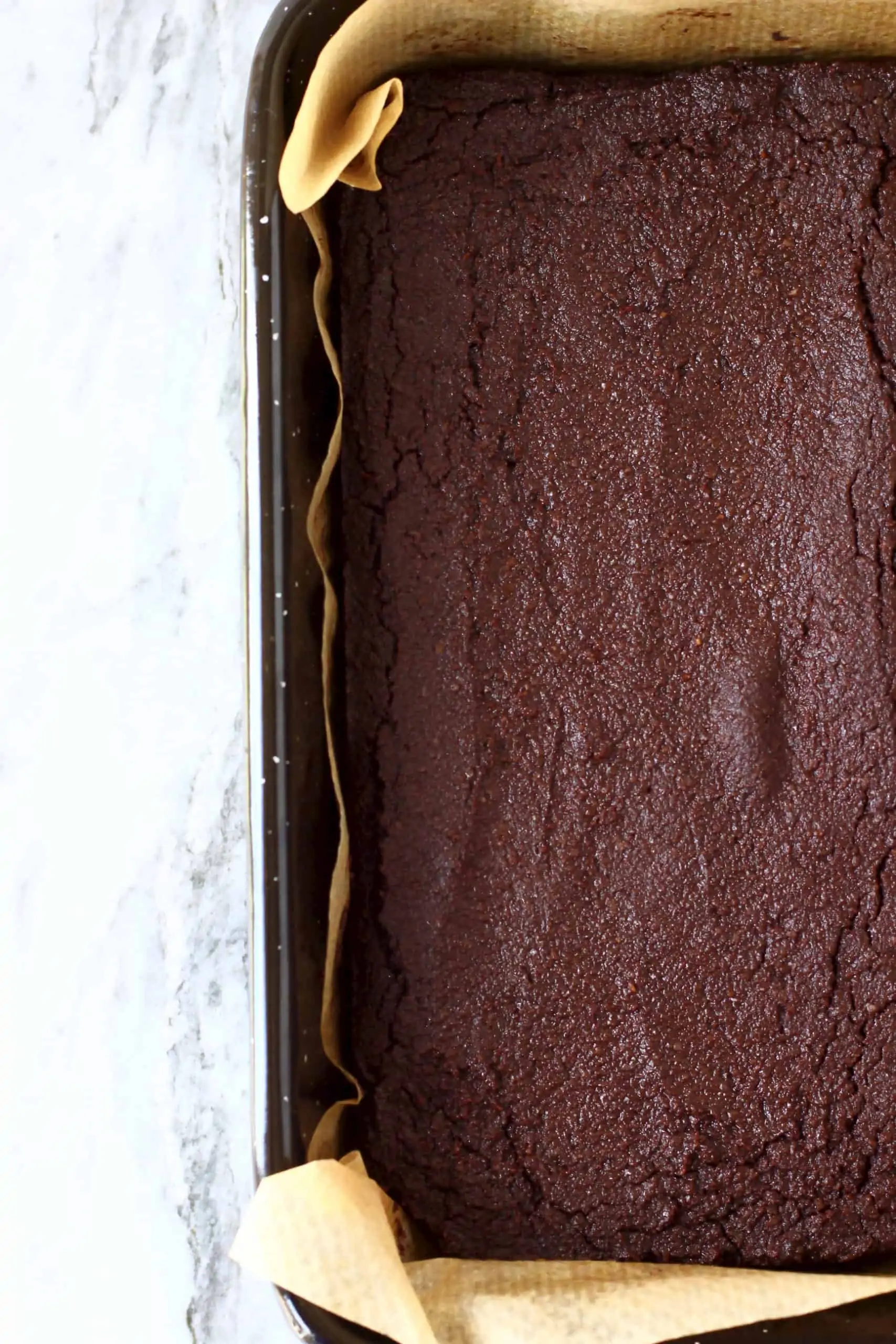 Vegan gluten-free chocolate brownies in a square baking tin lined with baking paper