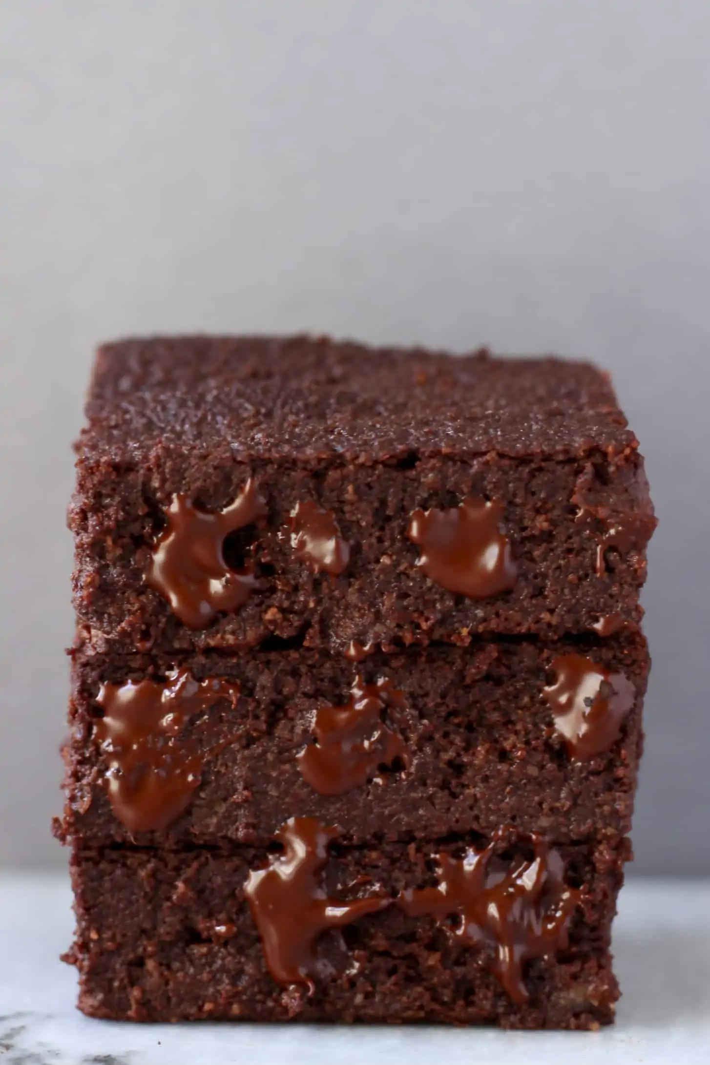 A stack of three square vegan gluten-free chocolate brownies