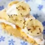 Photo of a slice of banana cream pie on a white plate with blue flowers