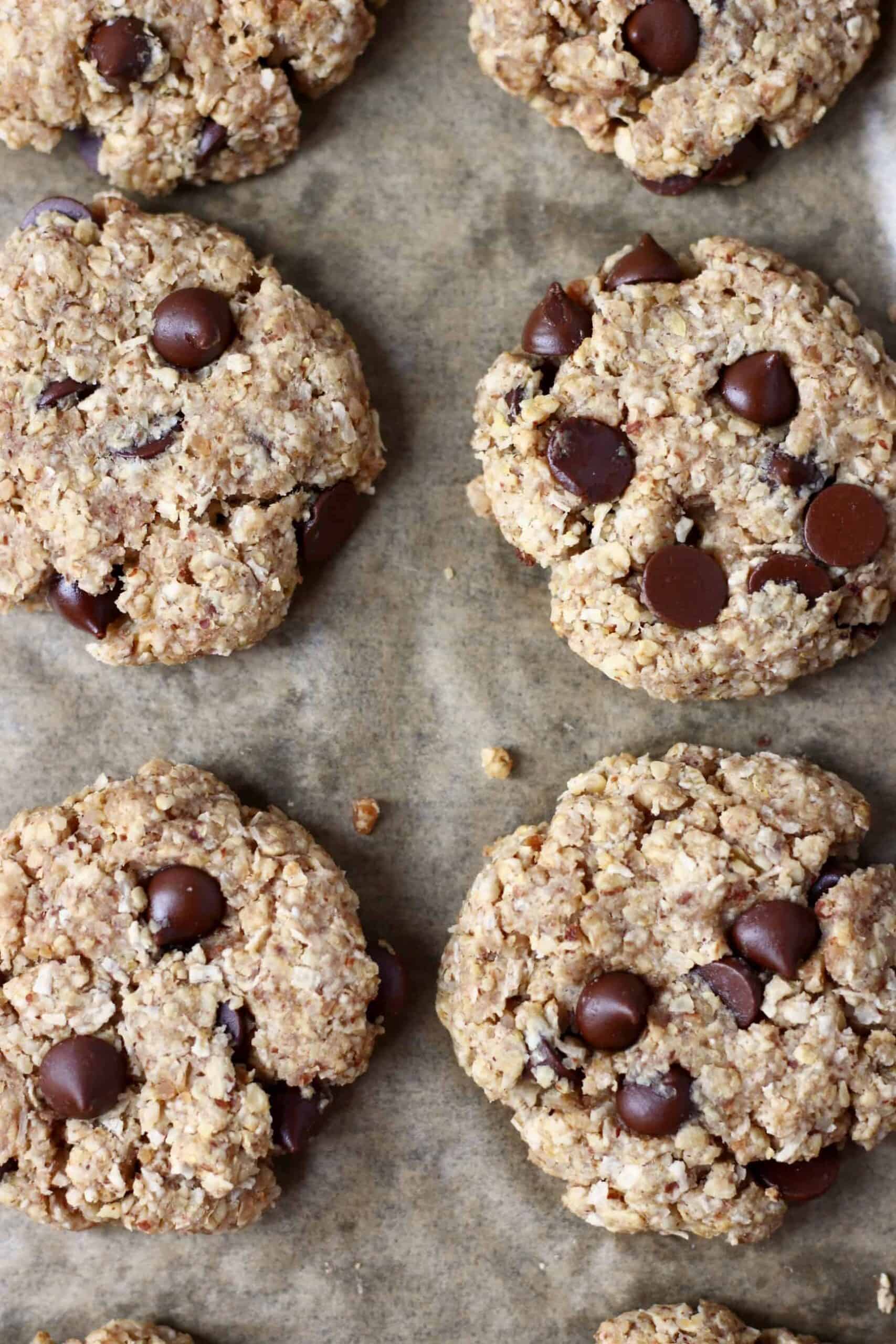Photo of six chocolate chip cookies on a piece of brown baking paper