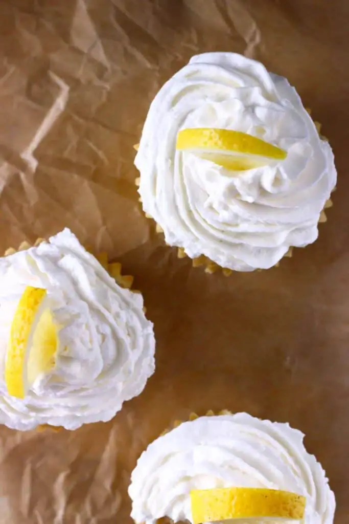Three lemon cupcakes with frosting shot from above