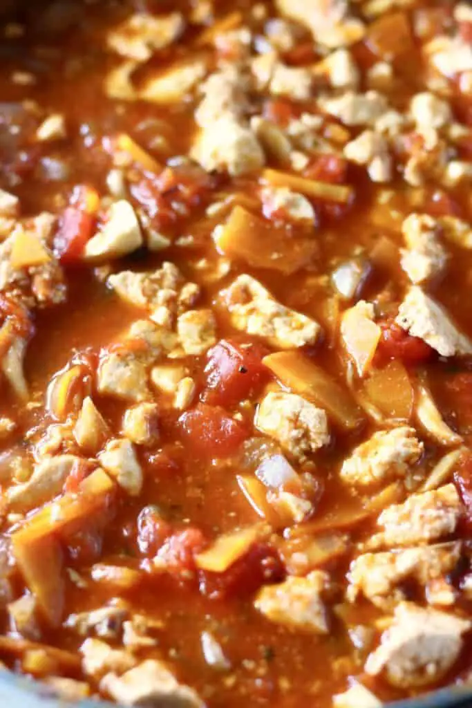Close-up photo of crumbled tofu and vegetables in a red tomato sauce